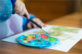 Ein Kind malt  auf einem Bild